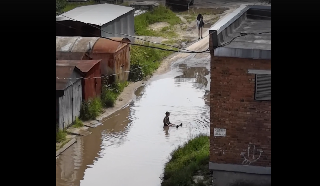 В Сыктывкаре ребенок устроил себе бассейн в луже посреди дороги (видео)