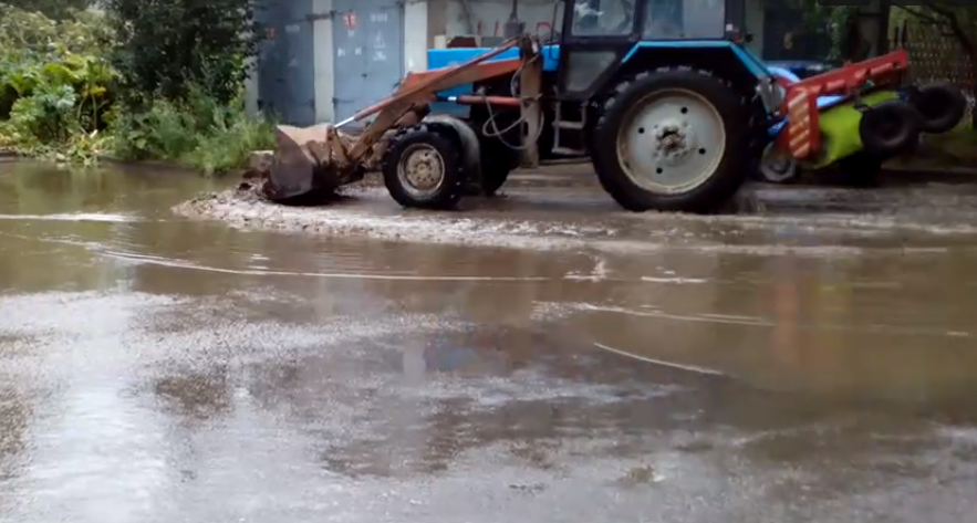 В одном из дворов Сыктывкара трактор выгонял ковшом огромную лужу (видео)