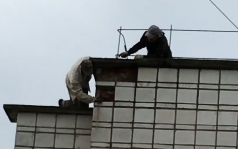 Суровым сыктывкарцам не нужна страховка: рабочий свисал с крыши на одной руке (видео)