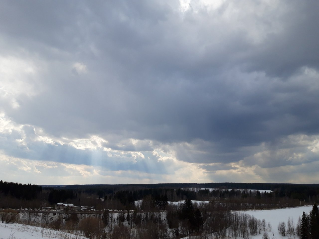 Фото дня в Сыктывкаре: лучи света пробиваются сквозь тучи над бескрайним лесами